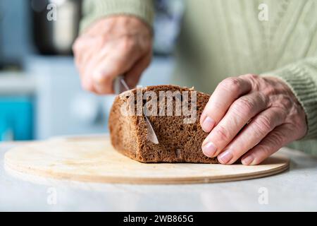 Fresh bread slice and cutting knife on table in the kitchen. Stock Photo