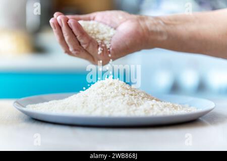 Two woman's hands holding jasmine rice, rice falling from hands, healthy and organic concept. top view Stock Photo