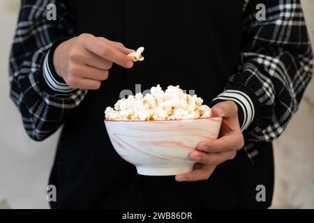 close-up of popcorn in the hands. Girl holding bowl of popcorn Stock Photo