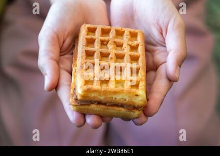 Crop person holding appetizing sweet Belgian waffles with chocolate Stock Photo