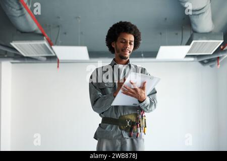 Portrait of foreman inspecting construction site and taking notes in document Stock Photo