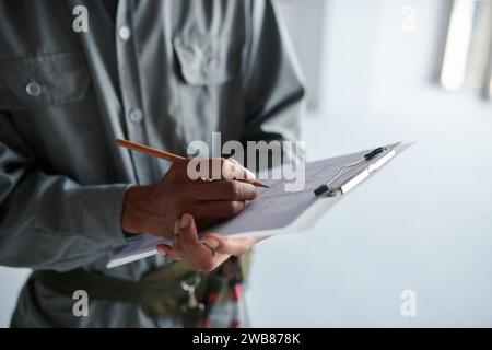 Cropped image of construction worker checking building plan on clipboard Stock Photo