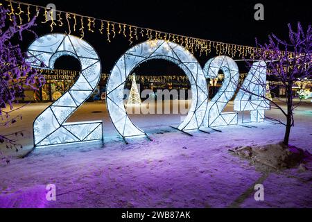 Happy New Year 2024. Sparkling burning numbers Year 2022 with on black background. Beautiful design element. christmas street decorations. snowfall mo Stock Photo