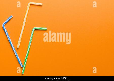 Drinking straws for party on Colored background. Top view of colorful plastic disposable straws for summer cocktails. different straws for juice with Stock Photo
