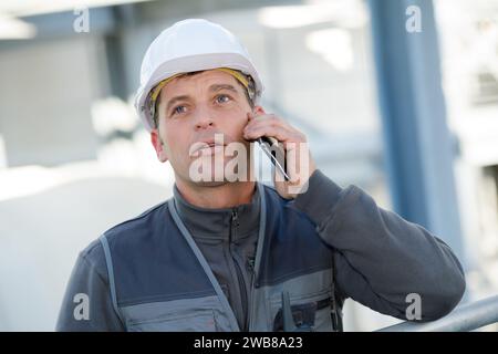 engineer man construction worker happy talking using a smartphone Stock Photo