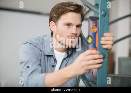 young man taking measures with spirit level Stock Photo