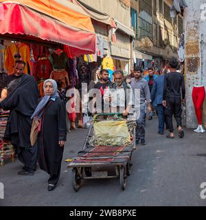 Local people walk along a narrow street in the Grand Bazaar area in Tehran, Iran. Stock Photo