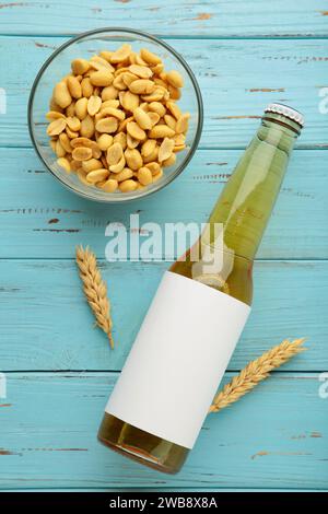 Glass of beer with peanuts on blue wooden background. Top view Stock Photo