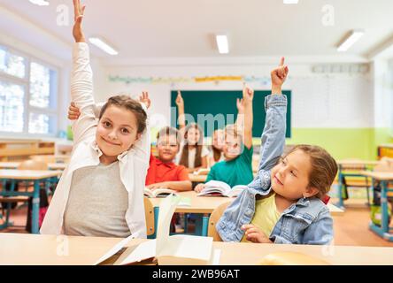 Portrait of schoolgirl (8-9) raising hand Stock Photo - Alamy