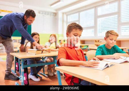 Group of elementary school children studying together in classroom Stock Photo