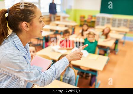Side view of elementary school teacher pointing during lecture in class Stock Photo