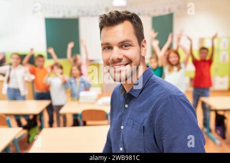 Portrait of smiling male teacher with students in background at school Stock Photo