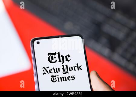 Dhaka, Bangladesh - 09 January 2024: Hands holding a smartphone with The New York Times logo on the screen. The New York Times is an American newspaper. Stock Photo