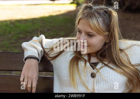 a teenage girl of fair appearance with a piercing in the nose dressed in a white jacket black jeans Stock Photo