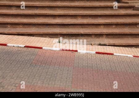 Red white curb paint marking in Morocco. No parking marking. Stock Photo