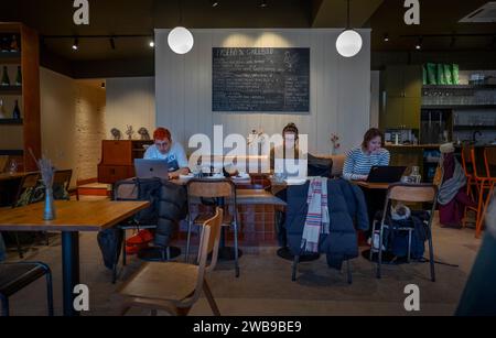 Young Professionals Working on Laptop Computers in Cafe Bar London January 2024 Stock Photo