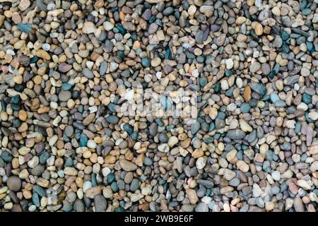 Small stone texture for background. Gravel background. Smooth round pebbles texture background. Pebble sea beach close-up, dark wet pebble and gray dr Stock Photo