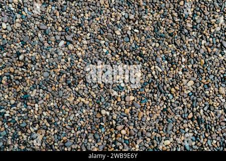 Small stone texture for background. Gravel background. Smooth round pebbles texture background. Pebble sea beach close-up, dark wet pebble and gray dr Stock Photo