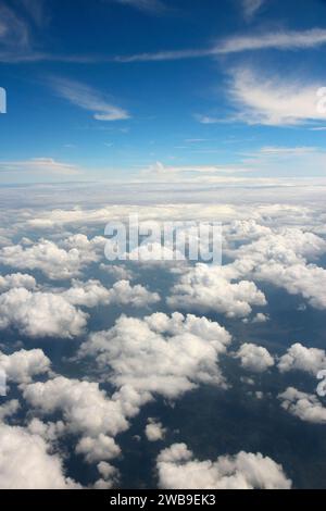 Flying a aircraft over fluffy cumulus clouds, aerial view Stock Photo ...