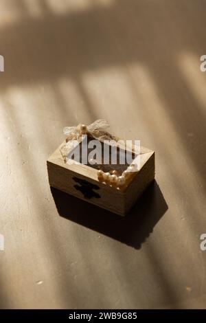 Wooden wedding rings box on a table with golden light coming through the windows. Bride and groom rings in a box. Stock Photo