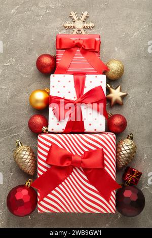 Christmas gift boxes laid out in the shape of a Christmas tree on grey background. Top view. Stock Photo