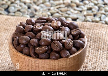 Green coffee with roasted coffee beans on burlap sack,top view Stock Photo