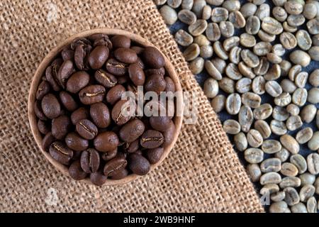 Green coffee with roasted coffee beans on burlap sack,top view Stock Photo