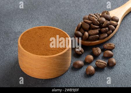 Coffee beans with a bowl of ground coffee on black background Stock Photo