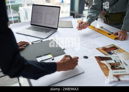 Hands of architects working on building blueprint for client Stock Photo