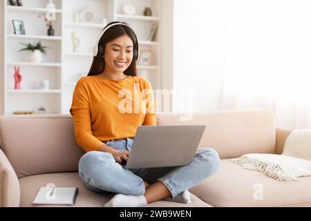 Happy millennial chinese woman attending webinar from home Stock Photo