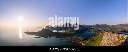A panoramic view from Offersoykammen peak, with the midnight sun glistening on the Nappstraumen and the rugged landscapes of Vestvagoya and Flakstadoy Stock Photo