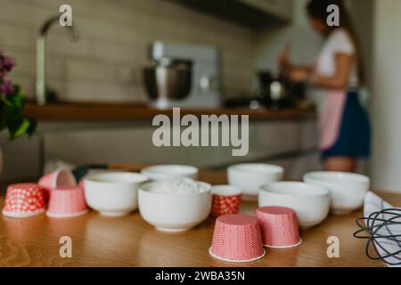 Variety of cupcake liners in different colors with a muffin pan and wire whisk. Stock Photo