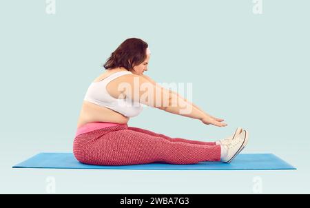 Side view shot of funny chubby overweight woman doing sports Stock Photo