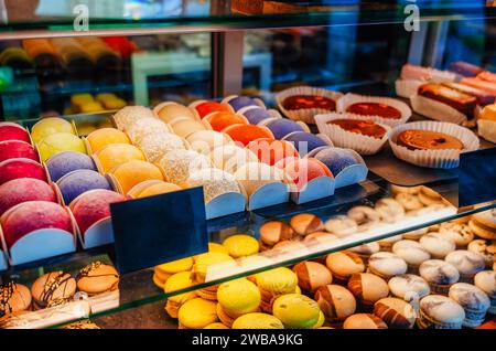 Sweets, cakes of different colors in the window of cafe store Stock Photo