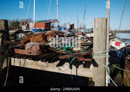 Wooden boat mooring with piles of old junk on the jetty Skippool creek Lancashire UK Stock Photo