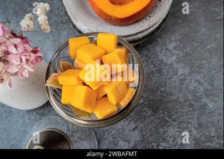 Jellied candy, candied pumpkin in a glass candy bowl. Homemade pumpkin candies close-up. Copy space Stock Photo