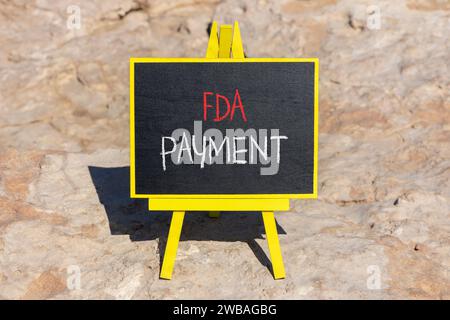 FDA Food and Drug Administration payment symbol. Concept words FDA payment on beautiful black chalk blackboard. Beautiful red stone background. Busine Stock Photo