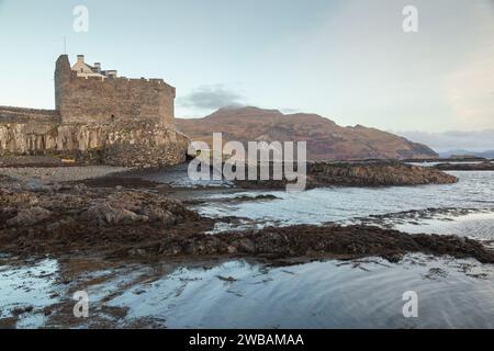 Mingary Castle (Mingarry Castle) with Ben Hiant behind is a castle situated one mile southeast of the small village of Kilchoan in Lochaber, Scotland Stock Photo