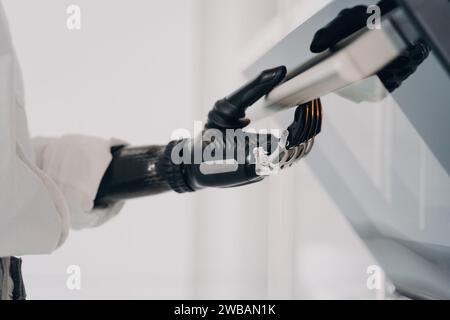 Precision and technology converge as a bionic hand operates a control panel, symbolizing the new era of human-machine integration Stock Photo