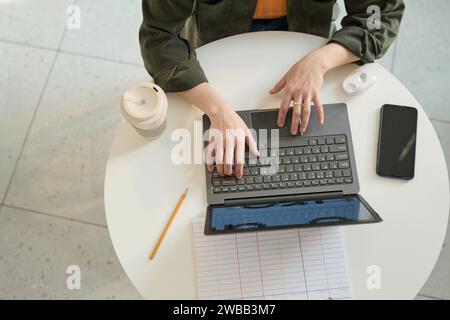 Flat lay shot of unrecognizable female freelancer working on portable computer remotely Stock Photo