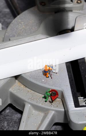 Miniature scale model workers on an electric circular saw.  Construction concept. Stock Photo