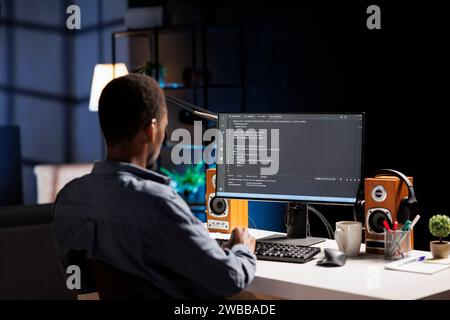 Male developer entering binary data on terminal panel while establishing html code. Software engineer works on troubleshooting with programming language, for protection of databases. Stock Photo