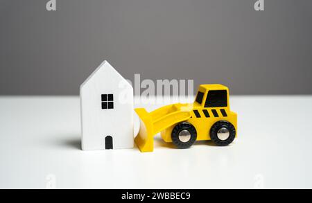 Bulldozer demolishes house, concept. Illegal buildings construction. Plan for the renewal and restoration of residential areas. Lawsuit. Illegal const Stock Photo