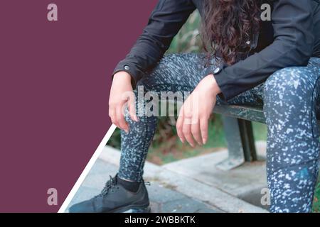 Silhouette of young female athlete rests body after exercise. Sporty, strong and healthy woman sitting in the park after exercise. Stock Photo