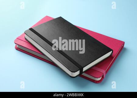 Black and pink notebooks on light blue background Stock Photo