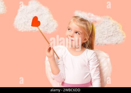 Cute little thoughtful girl dressed as cupid with arrow and clouds on pink background. Valentine's Day celebration Stock Photo