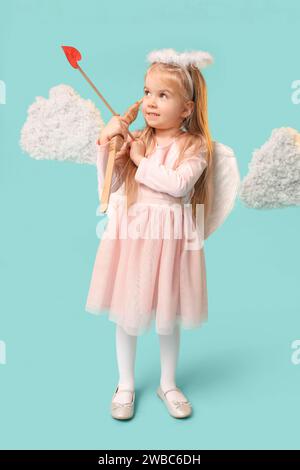 Cute little girl dressed as cupid with arrow, bow and clouds on blue background. Valentine's Day celebration Stock Photo