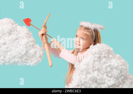 Cute little girl dressed as cupid with bow, arrow and clouds on blue background. Valentine's Day celebration Stock Photo