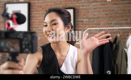 Woman influencer shoot live streaming vlog video review clothes social media or blog. Happy young girl with apparel vivancy studio lighting for Stock Photo