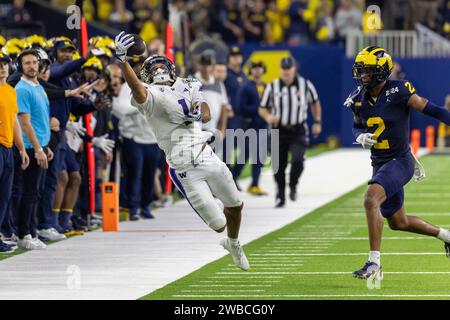 Washington Huskies wide receiver Rome Odunze (1) attempts a one handed catch on the sideline past the defense of Michigan Wolverines defensive back Wi Stock Photo